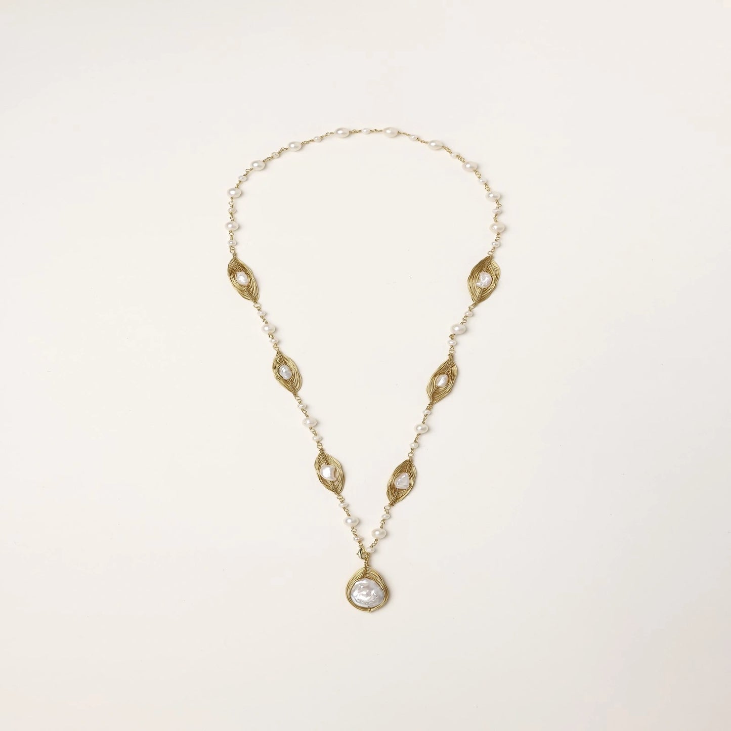 14K gold plated necklace with organic leaf motifs and freshwater pearls arranged in an elegant chain design on neutral background.