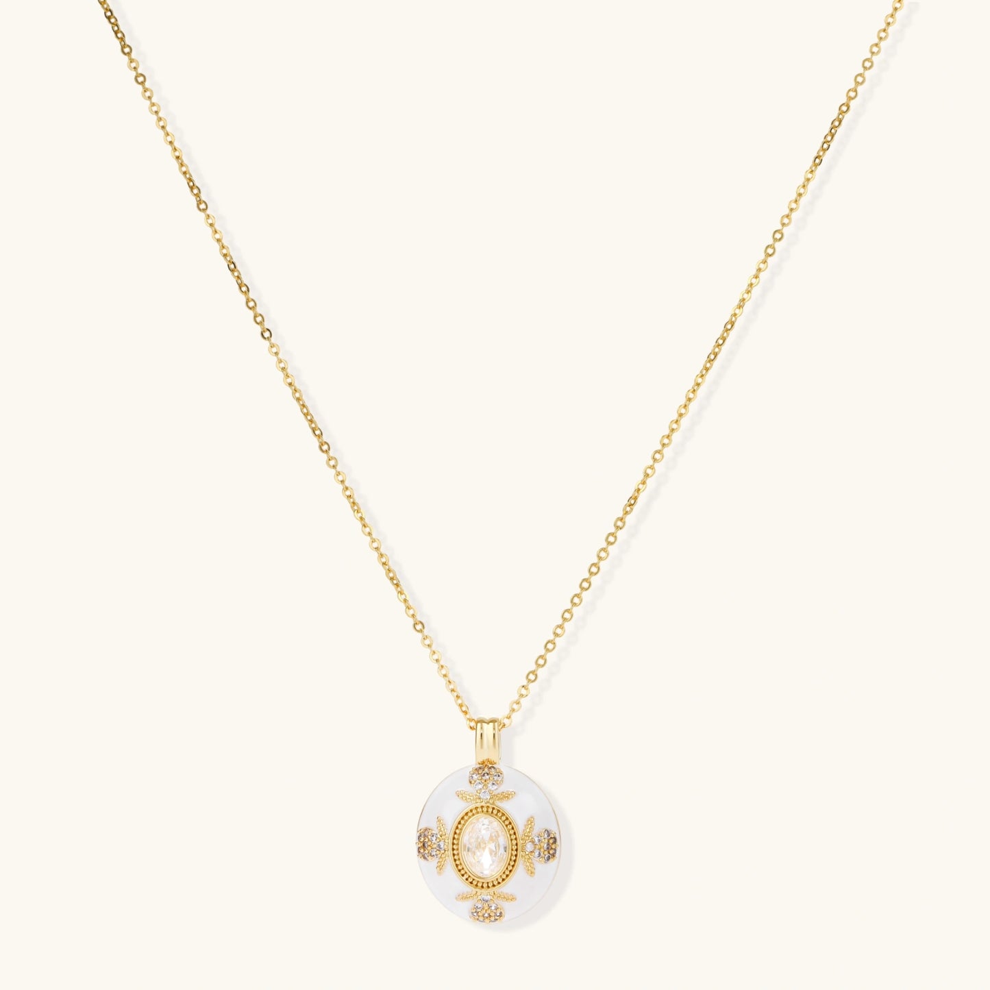 Gold-plated necklace with circular white enamel pendant featuring central zirconia stone and ornate decorative details