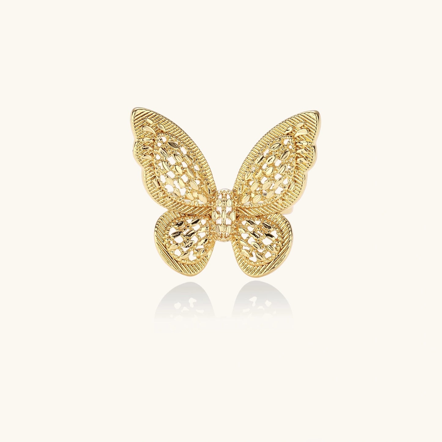 Intricate gold-plated butterfly ring with filigree cutout wings and adjustable band on white background.